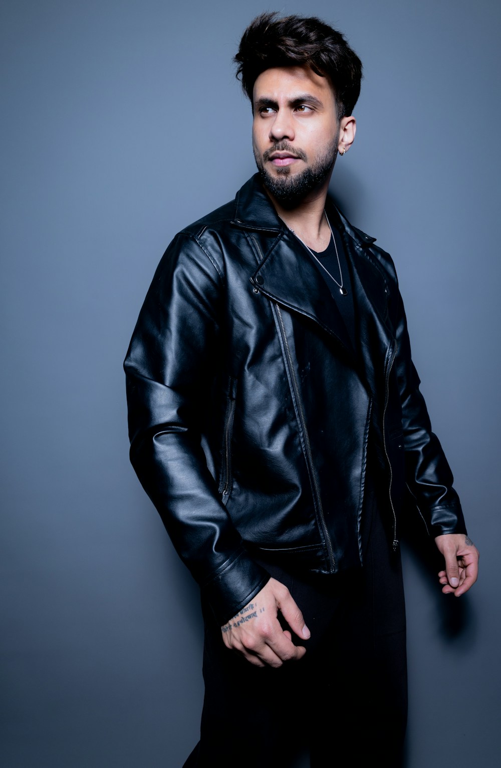 A character shot: wardrobe styled toward a castable type, plain studio background